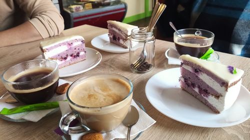 High angle view of hand holding coffee on table