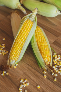 Fresh ear of corn lay down on the table with corn kernels.