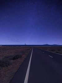 Empty road against blue sky