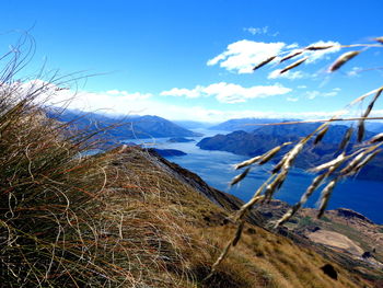 Scenic view of lake and mountains against blue sky