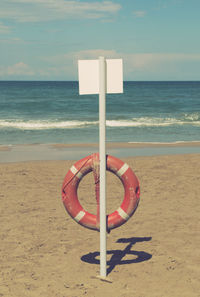 Lifeguard hut on beach against sky