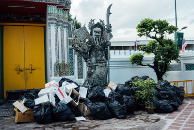 Statue by building against trees