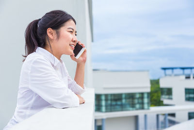 Side view of woman looking at city