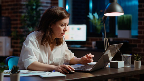 Businesswoman using laptop at table