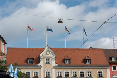 Low angle view of flags on building against sky