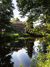 Reflection of building on lake against sky