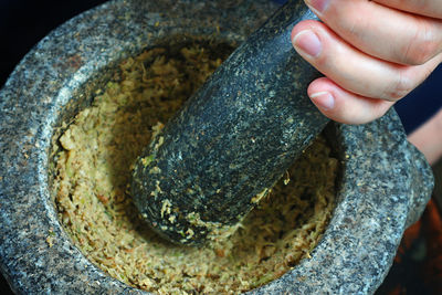 High angle view of person hand on stone