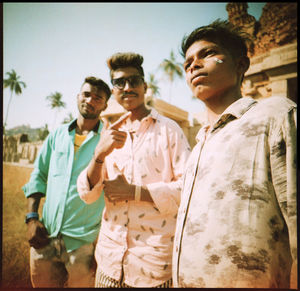 Portrait of young men standing against the sky