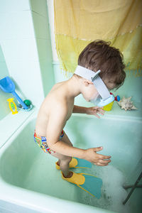 Full length of shirtless boy playing in swimming pool