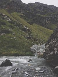 Scenic view of river amidst mountains against sky