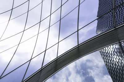 Low angle view of suspension bridge against cloudy sky