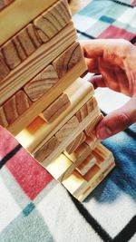 Cropped hand of person playing with toy blocks on table