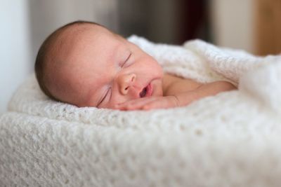 Close-up of baby sleeping on bed