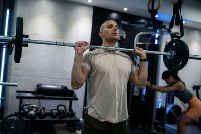 Shirtless man exercising in gym