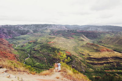 Rear view of people on mountain against sky