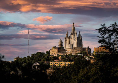 Panoramic view of buildings and trees against sky