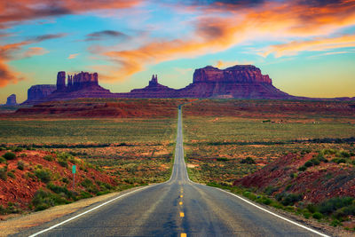 Empty road against sky during sunset