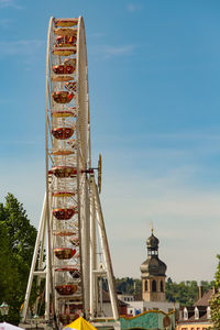 Low angle view of ferris wheel against buildings