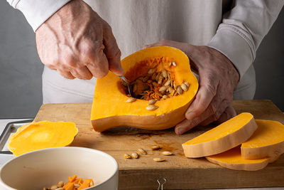 Midsection of man with pumpkin on table