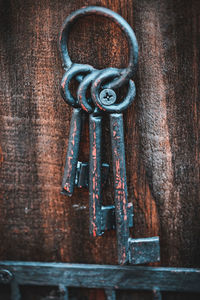 Close-up of rusty metal hanging on wood