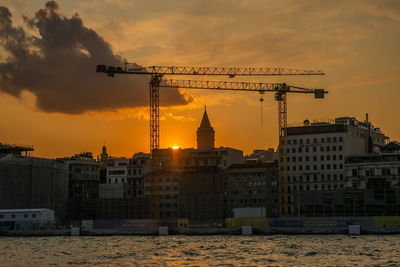 Buildings in city against sky during sunset