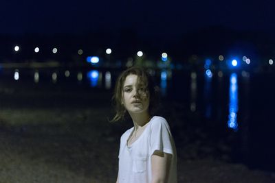 Portrait of girl standing at beach during night