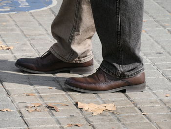 Low section of man standing on footpath