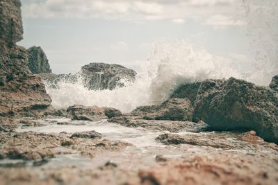 Rocks in sea against sky