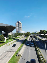 Vehicles on road against sky in city