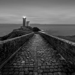 Footpath by sea against sky