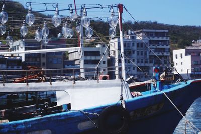 Boats moored at harbor against sky