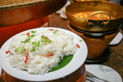 Vermicelli in plate over container