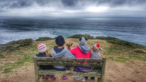 Rear view of woman sitting on beach