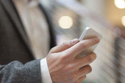 Midsection of man using mobile phone