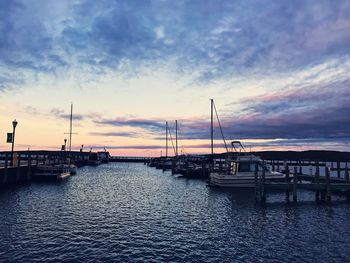 Silhouette boats sailing in sea against sky during sunset