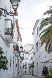 Narrow street amidst buildings against sky