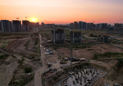 High angle view of street amidst buildings against sky during sunset