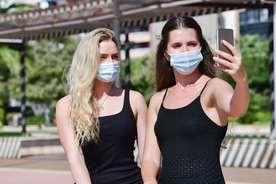 Portrait of young woman using mobile phone outdoors