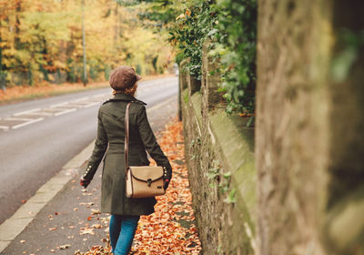 Rear view of man walking on road