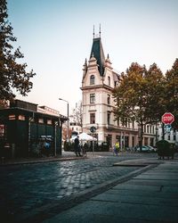 Street by building against sky in city