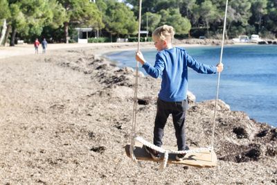 Rear view of man standing at beach