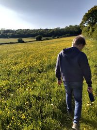 Rear view of man walking on field