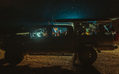 People sitting on illuminated street at night