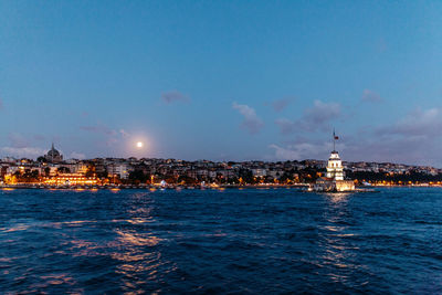 Illuminated sea against sky at night