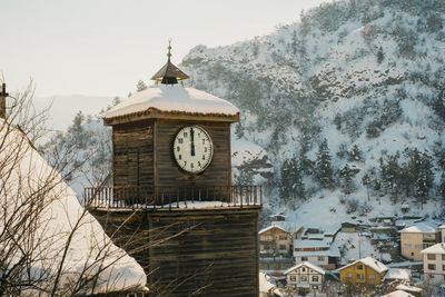 Wooden clock tower and snowy village landscape