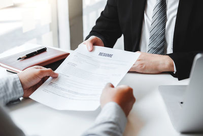 Midsection of man holding hands on table