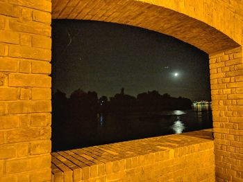 Reflection of illuminated building in swimming pool at night