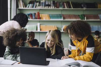 Portrait of diverse students studying together through e-learning in classroom