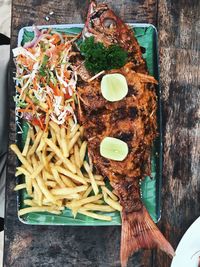 Directly above shot of fried fish with french fries served in tray