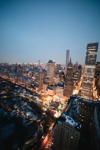 High angle view of illuminated cityscape against clear sky